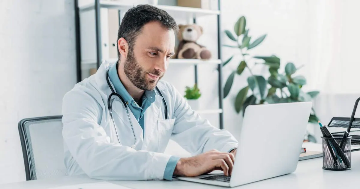 A doctor working on a laptop.