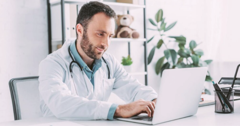 A doctor working on a laptop.
